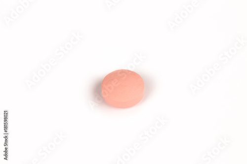 close-up of a salmon pink pill isolated on a white backgound.psd