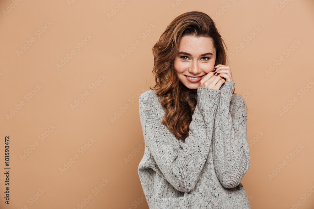 Close-up photo of tender smiling girl in soft knitted sweater looking at camera Close-up photo of tender smiling girl in soft knitted sweater looking at camera