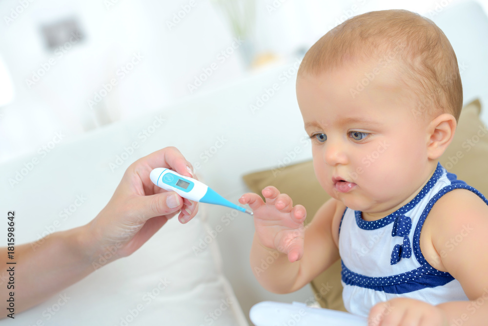 mom taking her sick childs temperature mom taking her sick childs temperature