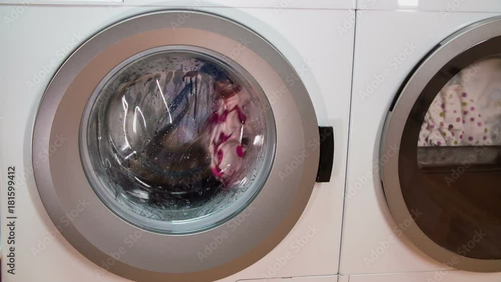 Washing machine and dryer in the utility room are working at full speed. They are washing laundry and drying clothes. Washing machine and dryer in the utility room are working at full speed. They are washing laundry and drying clothes.