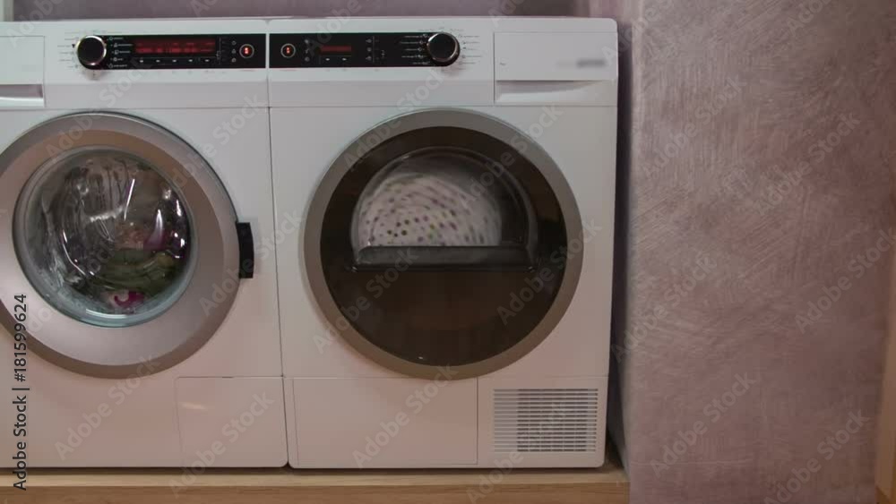 Advanced machines working in nice and tidy utility room. Dryer is working at full speed, washing machine is washing laundry. Advanced machines working in nice and tidy utility room. Dryer is working at full speed, washing machine is washing laundry.
