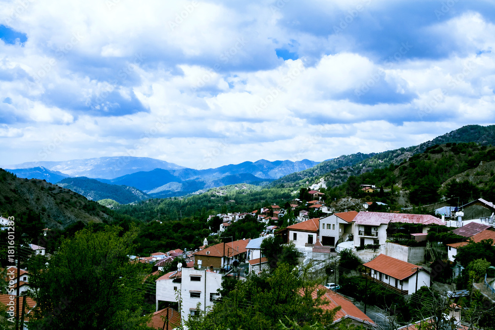 The landscape offers a view of the mountains, the forest and a small village with red roofs. Cyprus, Troodos