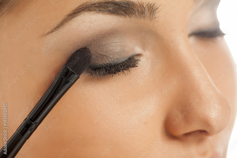 young beautiful woman applied eyeshadow with a brush