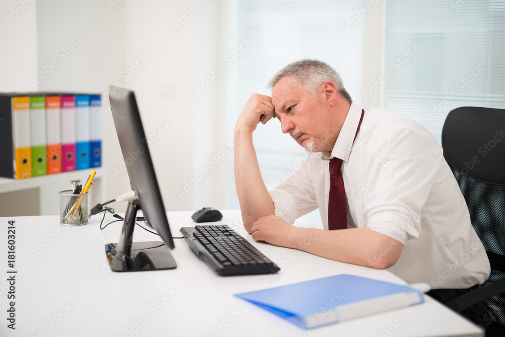 Fototapeta premium Sad businessman looking at his computer monitor