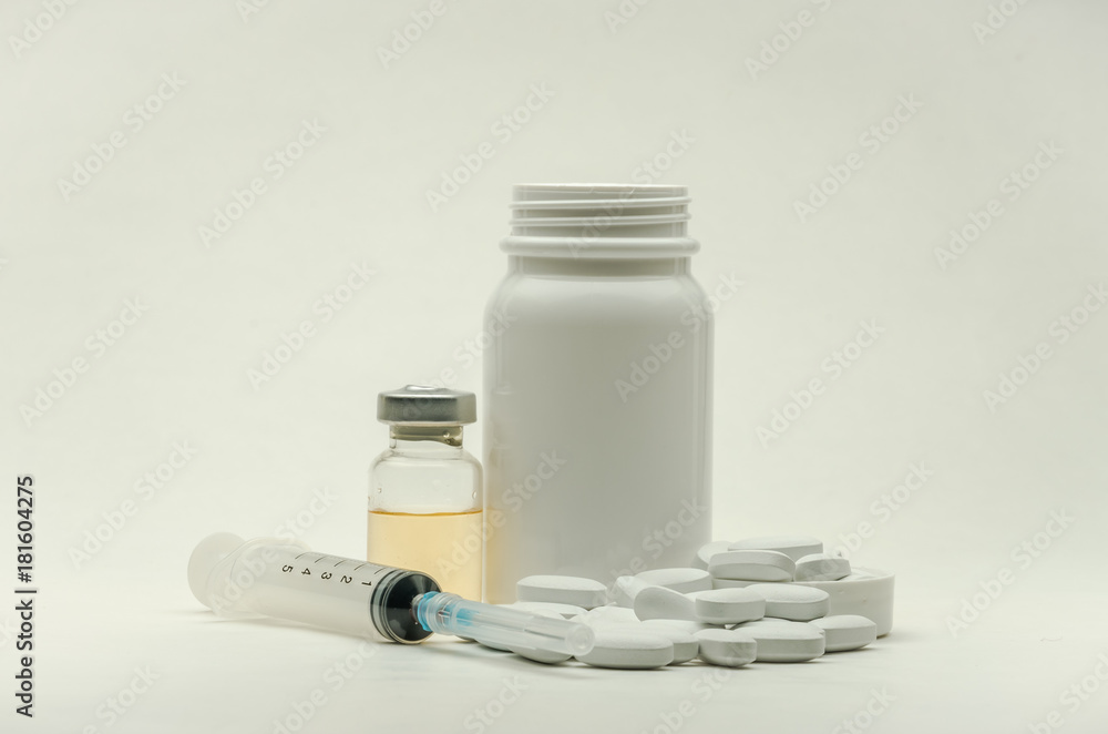 Pills, vitamins and syringe for injection with medications isolated on white background Pills, vitamins and syringe for injection with medications isolated on white background