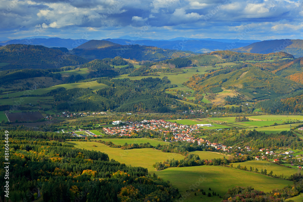 Krasnany town from Mala Fatra mountain. FView of the evening village from the mountains in Slovakia. Mountain forest with storm clouds on sky. Sunset in Slovakia. Autumn landscape in Europe.