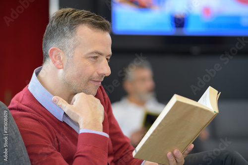 patient reading a book in doctors waiting room