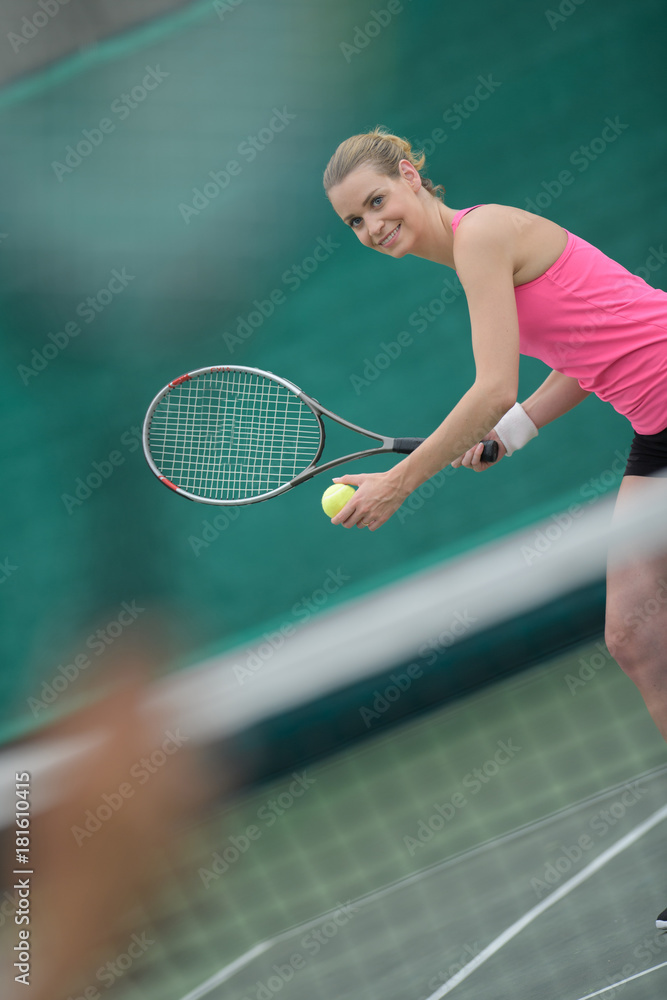 Lady poised to serve tennis ball