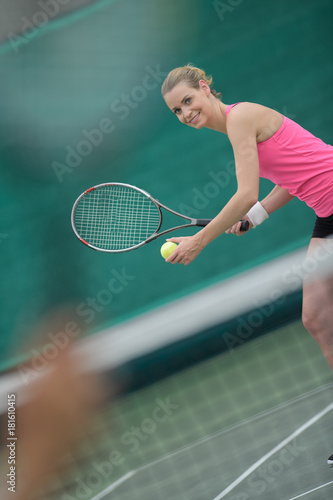 Lady poised to serve tennis ball