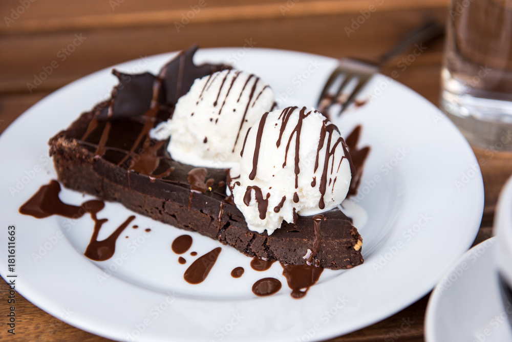 Brownie cake with vanilla ice cream served on white plate Brownie cake with vanilla ice cream served on white plate