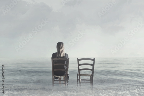 alone woman sitting next to her lover's empty chair