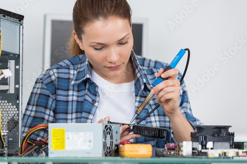 Female technician using soldering iron