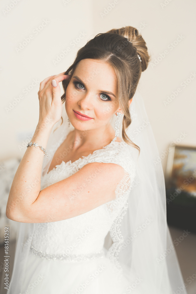 Gorgeous bride in robe posing and preparing for the wedding ceremony face in a room Gorgeous bride in robe posing and preparing for the wedding ceremony face in a room