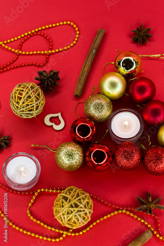 Golden and red balls on the red background. Candles in decorations. Set for celebrations