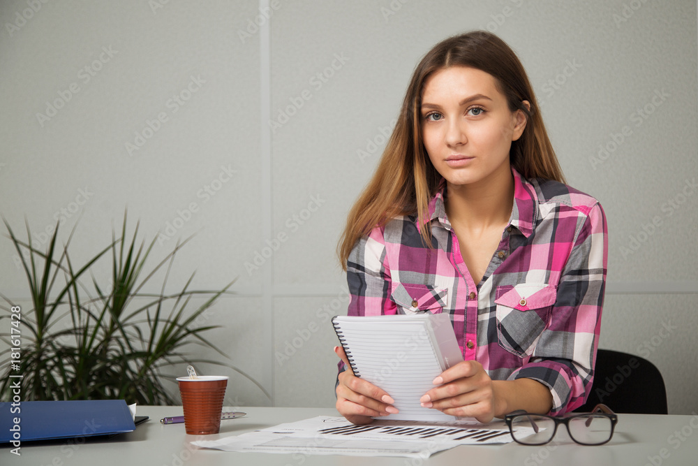 young businesswoman girl with glasses in casual wear sitting at the table carefully look at the documents young businesswoman girl with glasses in casual wear sitting at the table carefully look at the documents