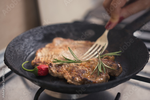 Pork steak cooked at the barbecue by a woman in her own kitchen