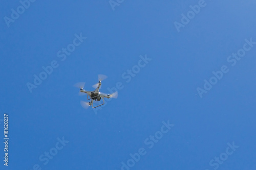 drone with the camera hovering in blue sky