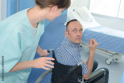 nurse helping a disabled man in wheelchair