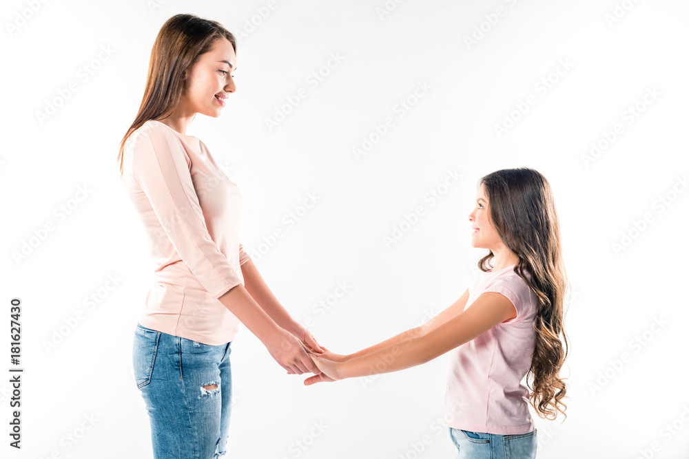 smiling mother and daughter holding hands smiling mother and daughter holding hands