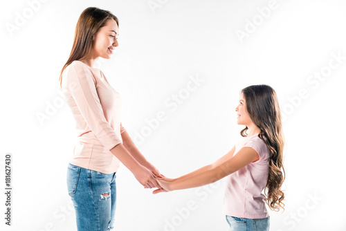 smiling mother and daughter holding hands