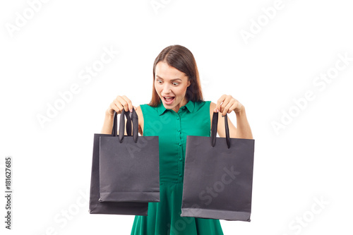 Portrait of female shopaholic holding black shopping bags