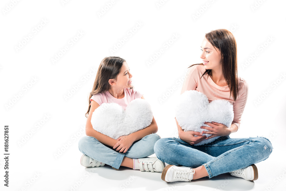 Daughter and mother with heart shaped pillows Daughter and mother with heart shaped pillows