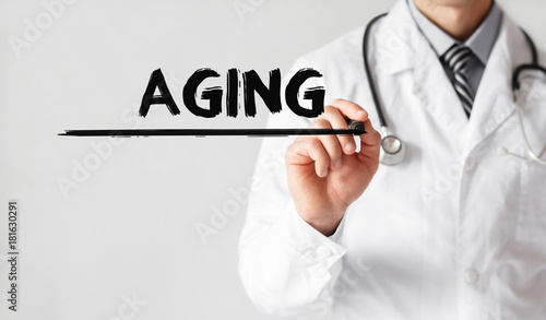 Doctor writing word Aging with marker, Medical concept