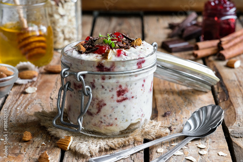 Fotografi overnight oatmeal in a jar with cherry jam and chocolate