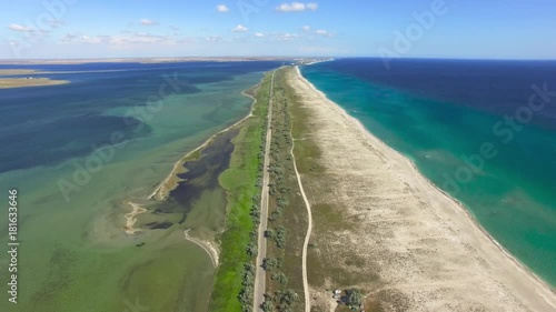 AERIAL: Salty land between the sea and salt lakes / Flying over salt lake and blue sea, aerial video, video shooting with drone photo