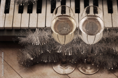 Artwork in vintage style, reflection of piano keys in two wine glasses, pianoforte, Christmas decoration