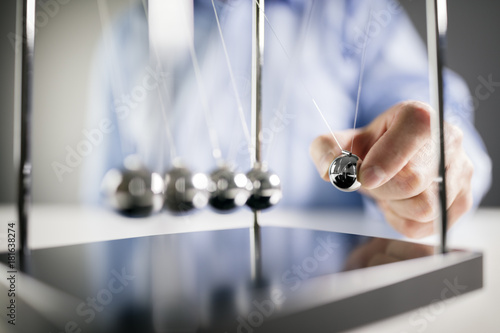 Newton's cradle businessman concept for cause and effect photo