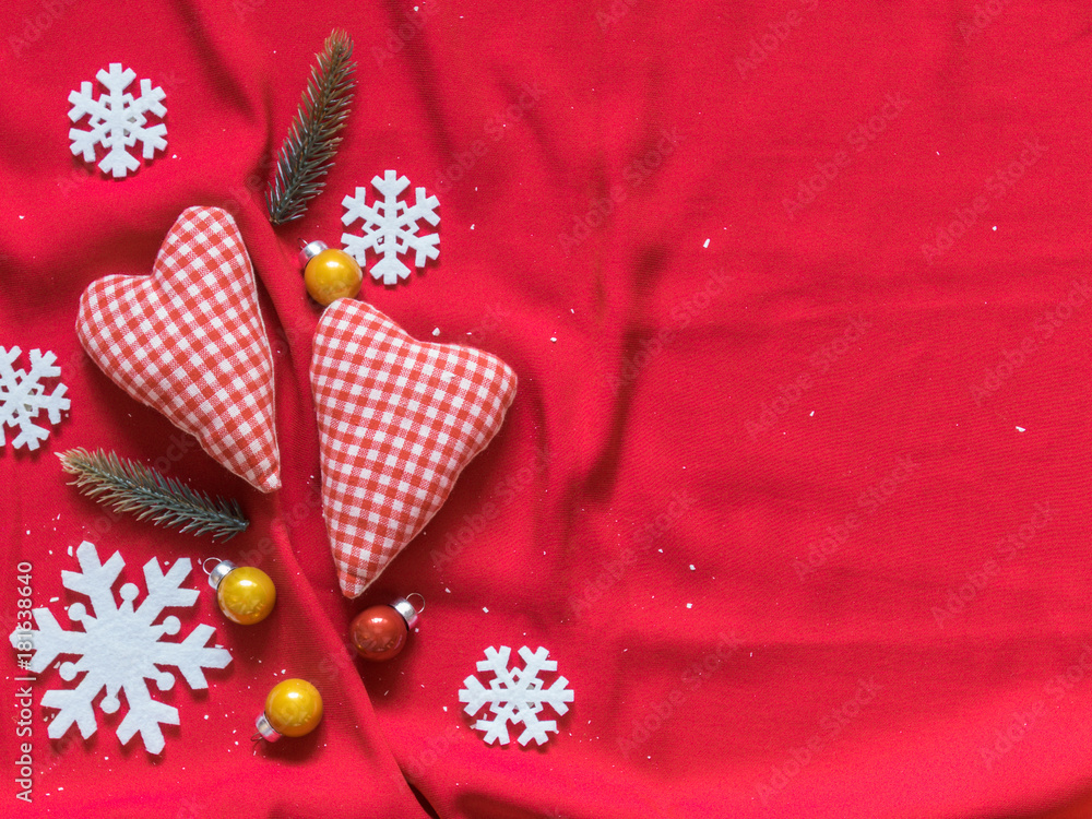 Two soft hearts, white snowflakes, Christmas balls on a red background. Christmas background. Valentine's day background. Free space for text. Top view