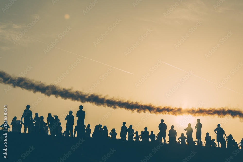 Sunset silhouettes watching an airshow Sunset silhouettes watching an airshow