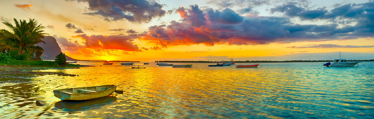 Acrylglasbilder Orange Fishing boat at sunset time. Le Morn Brabant on background. Panorama landscape  © Olga Khoroshunova