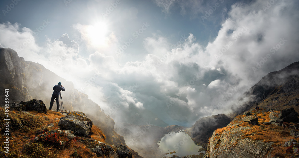 Fototapeta premium fotograf podróżnik z aparatu fotograficznego biorąc zdjęcie góry stoją na szczycie góry i ciesząc się zdjęcie