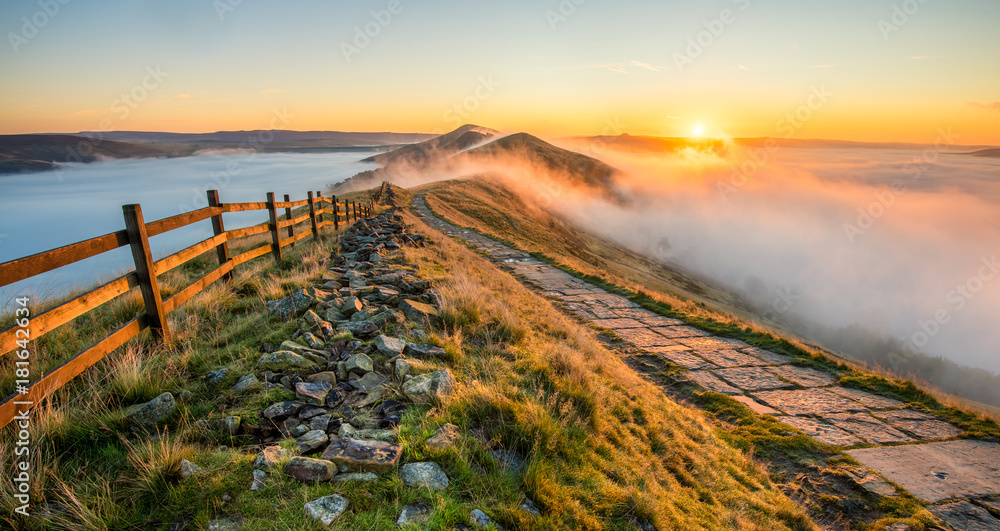 Thick cloud inversion with morning sun casting golden light on the landscape. Taken at Mam Tor in the English Peak District. - obrazy, fototapety, plakaty 