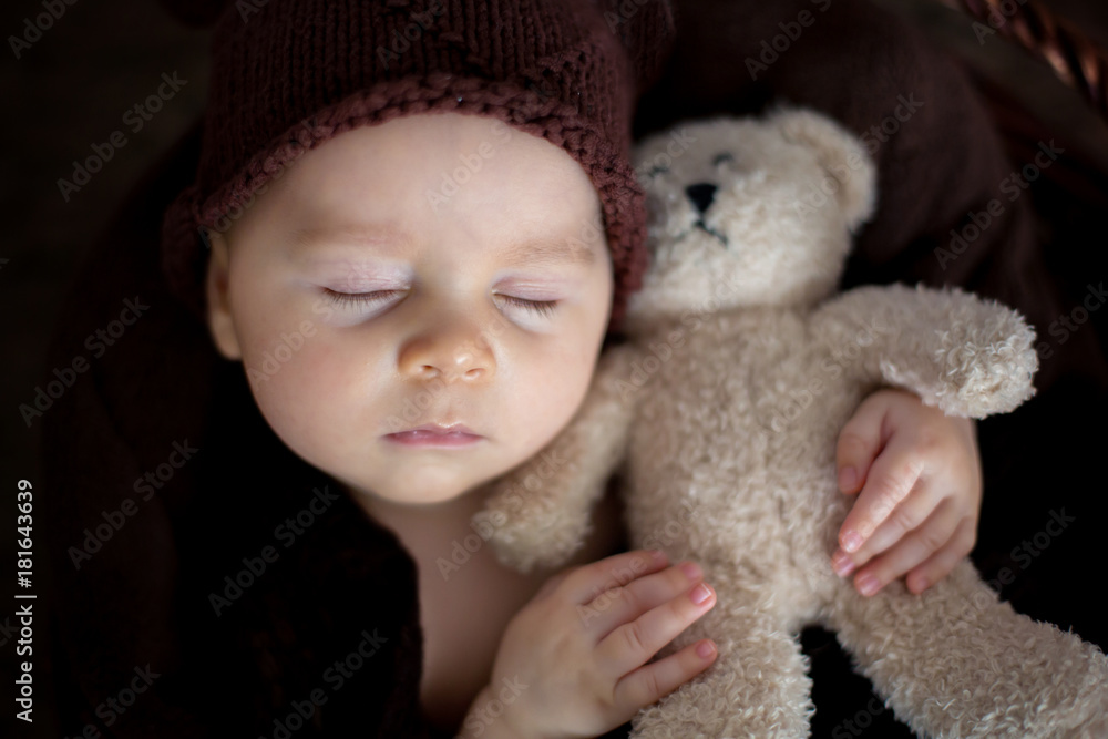 Cute three months old baby with bear hat in a basket, sleeping Cute three months old baby with bear hat in a basket, sleeping