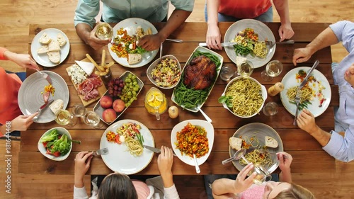 group of people eating at table with food