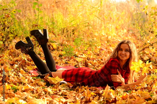 Outdoor fashion photo of young beautiful lady surrounded autumn leaves