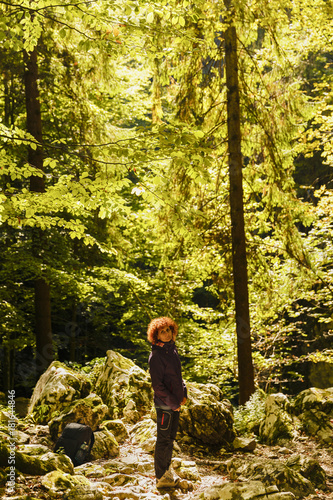 Woman hiker with backpack on a trail in the woods