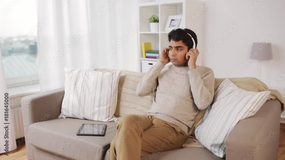 man with tablet pc and headphones at home man with tablet pc and headphones at home