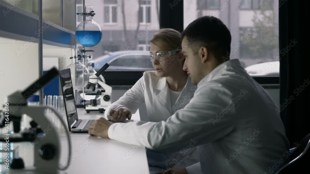 Professional scientists discussing research at lab Professional scientists discussing research at lab