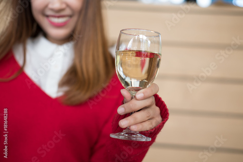 woman wearing red sweater holding wine glass for birthday or anniversary celebration. christmas, new year holiday. season greetings