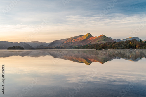 Morning golden light hitting mountains with calm reflections in lake. Taken at Derwentwater in the English Lake District.