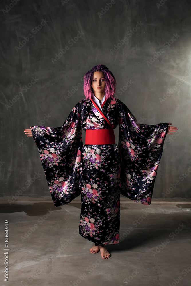 young girl with pink, curly hair in a colored kimono on a black background young girl with pink, curly hair in a colored kimono on a black background