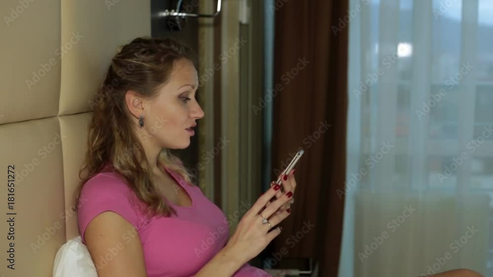 A woman talks on video communication using a smartphone. A woman talks on video communication using a smartphone.