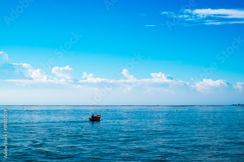 Silhouette fishing boat in the sea with blue sky