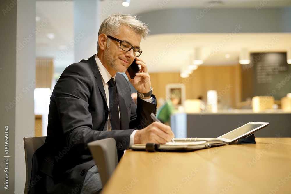 Businessman in restaurant talking on phone Businessman in restaurant talking on phone