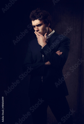 Thinking depression charismatic man looking down on dark shadow dramatic light background. Closeup portrait