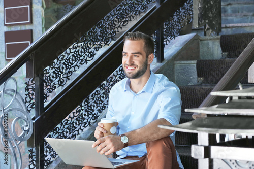 Handsome man with laptop si...